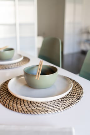 a table set with a bowl and chopsticks on a plate
