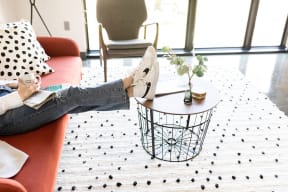 a woman sitting on a couch with her feet up on a coffee table