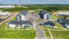 A large aerial view of a housing complex with a parking lot in the foreground.