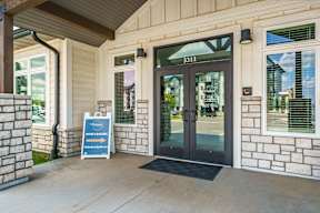 The entrance to a building with a sign that says "Now Leasing".