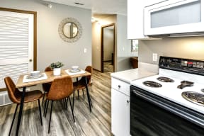 a kitchen with a table and chairs next to a stove