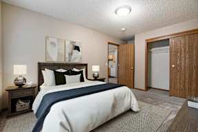 A bedroom with a large bed and a wooden headboard.
