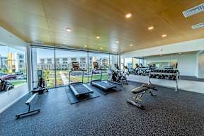 A gym with treadmills, exercise bikes, and other equipment.