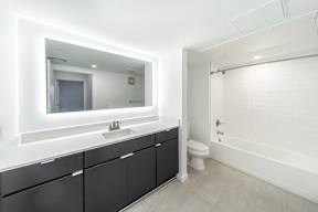 A bathroom with a sink, mirror, and toilet.