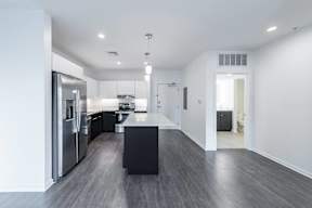 A modern kitchen with a black countertop and stainless steel appliances.