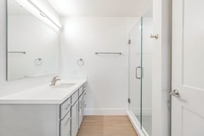 Bathrooms with custom quartz countertops and large soaking tubs at G at Market in Bentonville, AR
