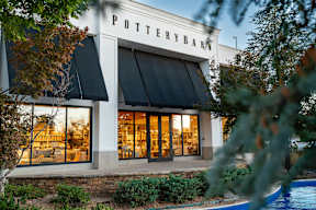 Pottery barn storefront with trees in front.