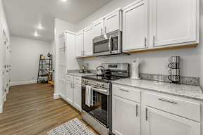 A kitchen with white cabinets and a black stove top oven.