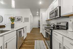 A modern kitchen with white cabinets and stainless steel appliances.