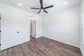 Bedroom with hard wood flooring at The Grove in Rogers, AR