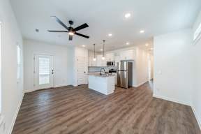 Spacious living room with hard wood floors at The Grove in Rogers, AR