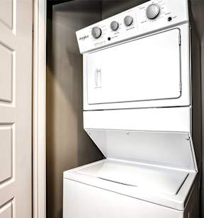 a white washer and dryer in a kitchen with a door