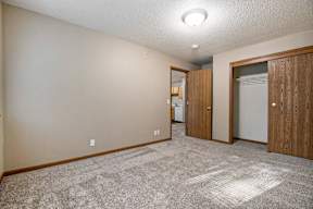 A room with a carpeted floor and a white ceiling light.