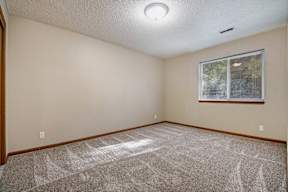 A room with a carpeted floor and a window.
