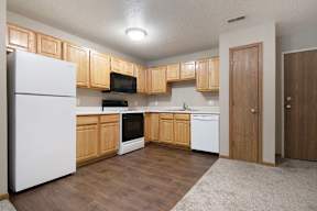 A kitchen with wooden cabinets and white appliances.