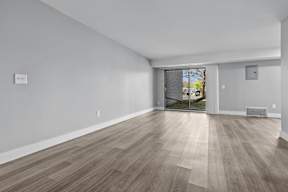 A room with light wood flooring and white walls.