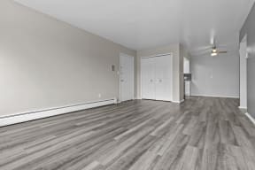 the living room and dining room of an empty house with wood flooring
