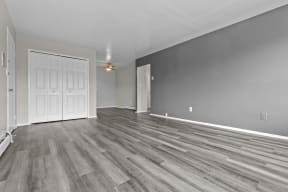 the living room and dining room of a new home with grey walls and wood floors