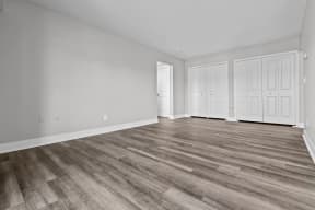 the living room of a new home with white walls and wood flooring