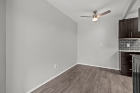 a living room with white walls and a ceiling fan