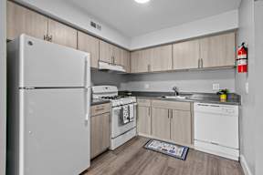 A kitchen with white appliances and wooden cabinets.