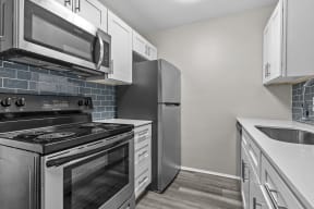a kitchen with stainless steel appliances and white cabinets