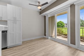 an empty living room with a sliding glass door to a balcony