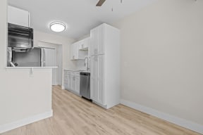 a renovated kitchen with white cabinets and a stainless steel refrigerator