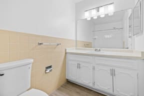 a bathroom with a toilet sink and mirror