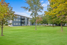the view of a building with grass and trees in front of it