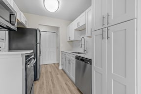 a white kitchen with stainless steel appliances and white cabinets