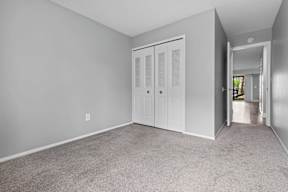 A room with a white door and carpeted floor.
