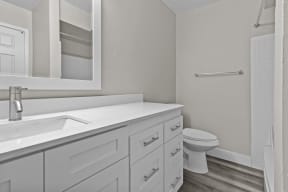 a bathroom with white cabinets and a toilet and a sink