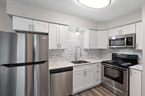 a kitchen with stainless steel appliances and white cabinets