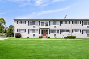 a white house with a green lawn in front of it