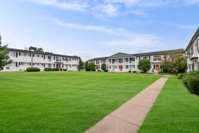 a lawn in front of a row of apartment buildings