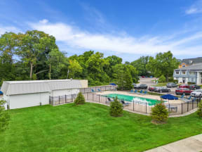 a yard with a swimming pool and a building with a parking lot