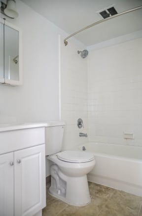 a white bathroom with a toilet and a shower