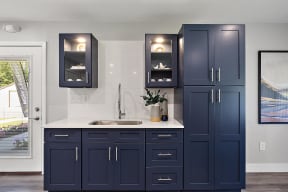 a kitchen with dark blue cabinets and a sink