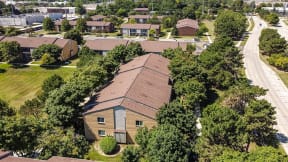 an aerial view of a house in a neighborhood with trees