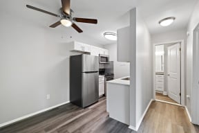 a kitchen with a refrigerator and a ceiling fan at Town & Country Apartments - Wixom, MI, Wixom, 48393