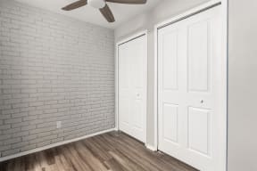 an empty room with white doors and a ceiling fan at Town & Country Apartments - Wixom, MI, Michigan