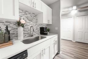 a kitchen with white cabinets and a sink1 at Town & Country Apartments - Wixom, MI, Wixom