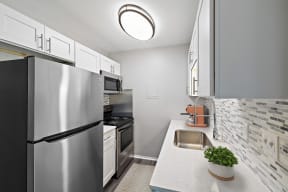 a kitchen with stainless steel appliances and a sink at Town & Country Apartments - Wixom, MI, Wixom, 48393