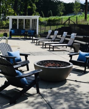 an outdoor seating area with chairs around a fire pit