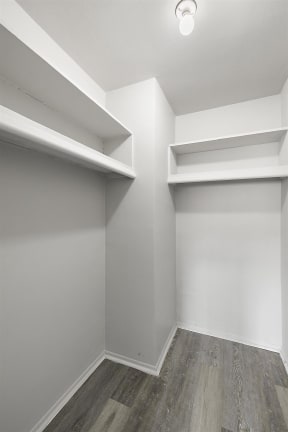 an empty room with white walls and wooden floors