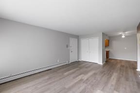 an empty living room with wood flooring and white walls