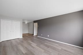 an empty living room with wood floors and a white door