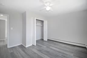 a living room with white walls and a ceiling fan