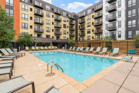 our apartments have a large swimming pool with lounge chairs at Be @ Axon Green, Minnesota, 55416